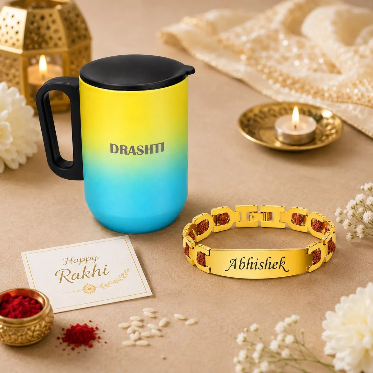 A personalized Rakhi gift set featuring a yellow-to-blue gradient travel mug with a black lid, a gold-plated bracelet engraved with 'Abhishek', a 'Happy Rakhi' greeting card, and festive decorative props on a beige surface.