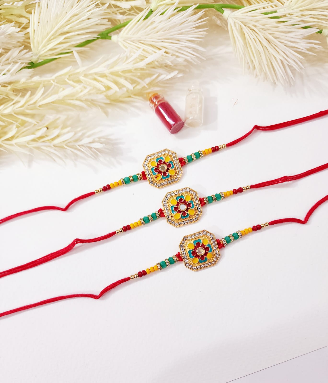 Two colorful rakhi with decorative beads on a white background