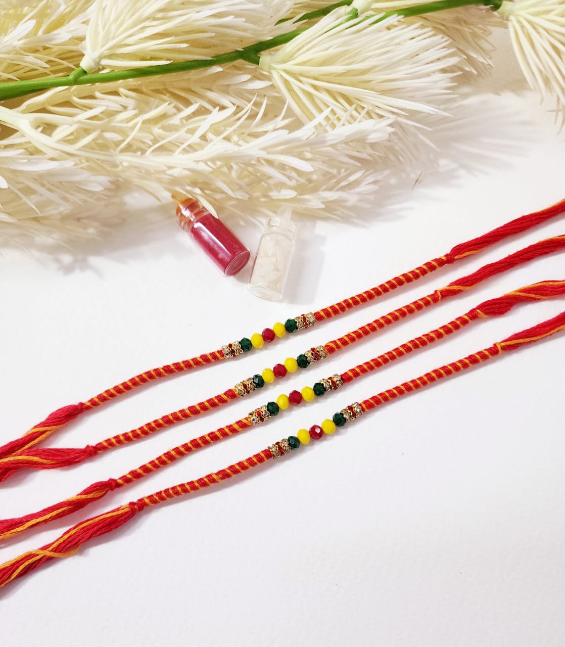 Three red strings with colorful beads on a white background