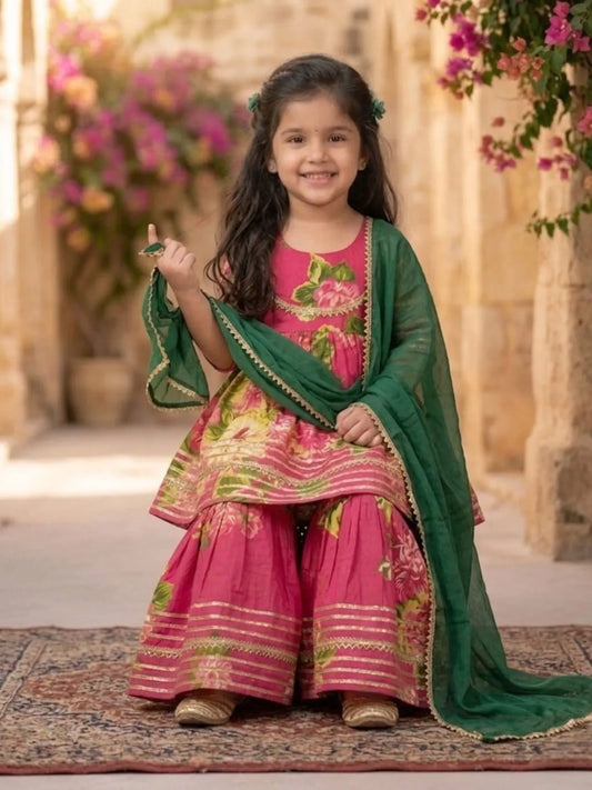 Girl sitting wearing pink floral sharara ethnic outfit