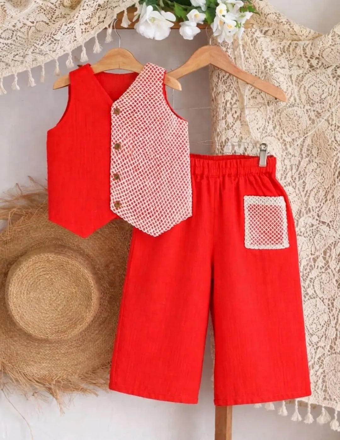 Close-up of red co-ord set showing contrast printed panel and button detailing