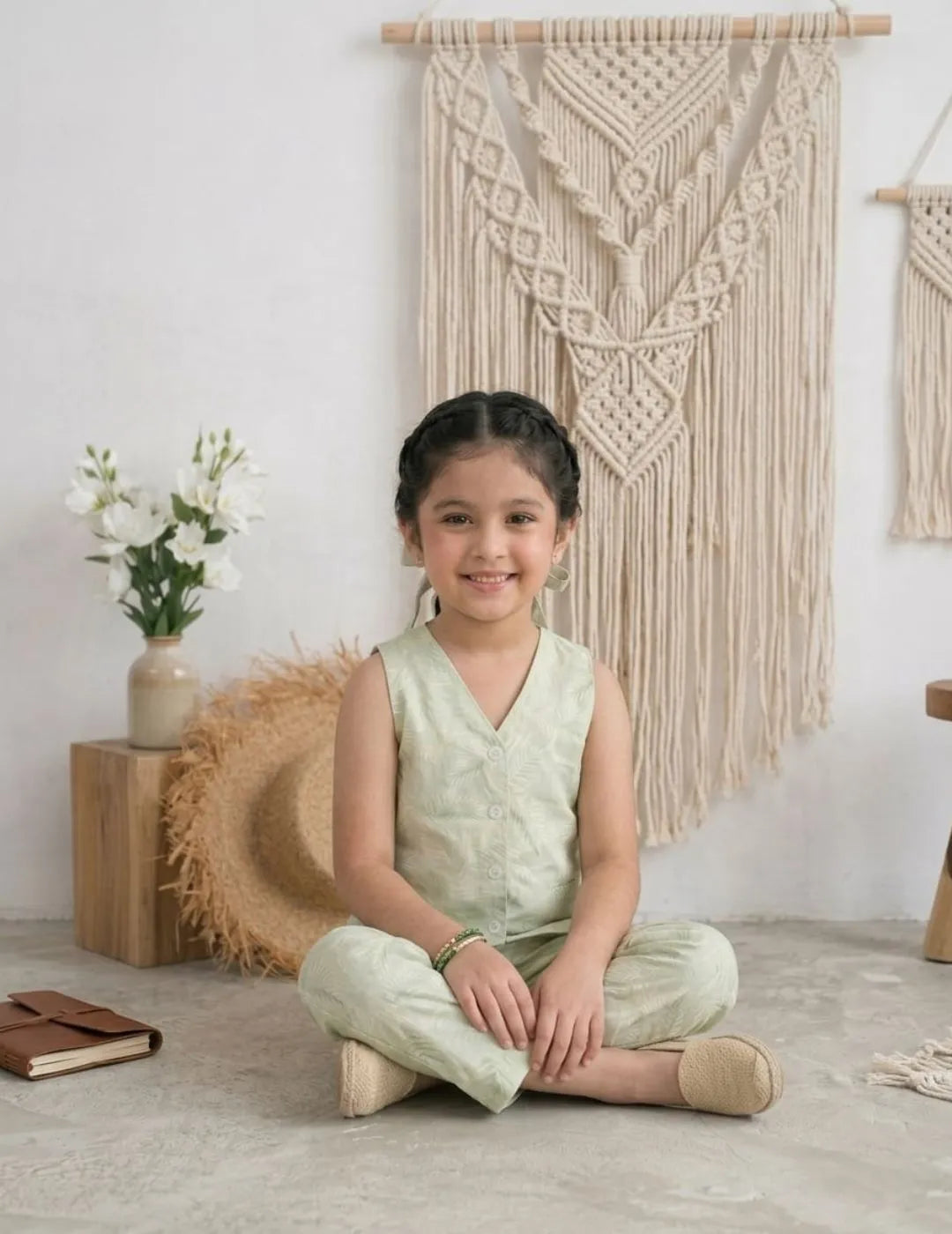 girl sitting wearing sage green cotton co-ord set vest and pants outfit