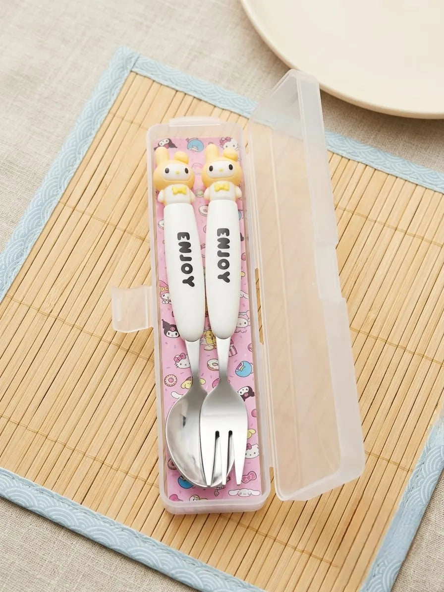 A set of two white baby utensils with cute cartoon character handles and 'ENJOY' printed on them, inside a clear plastic storage case with a pink patterned insert, placed on a bamboo mat.