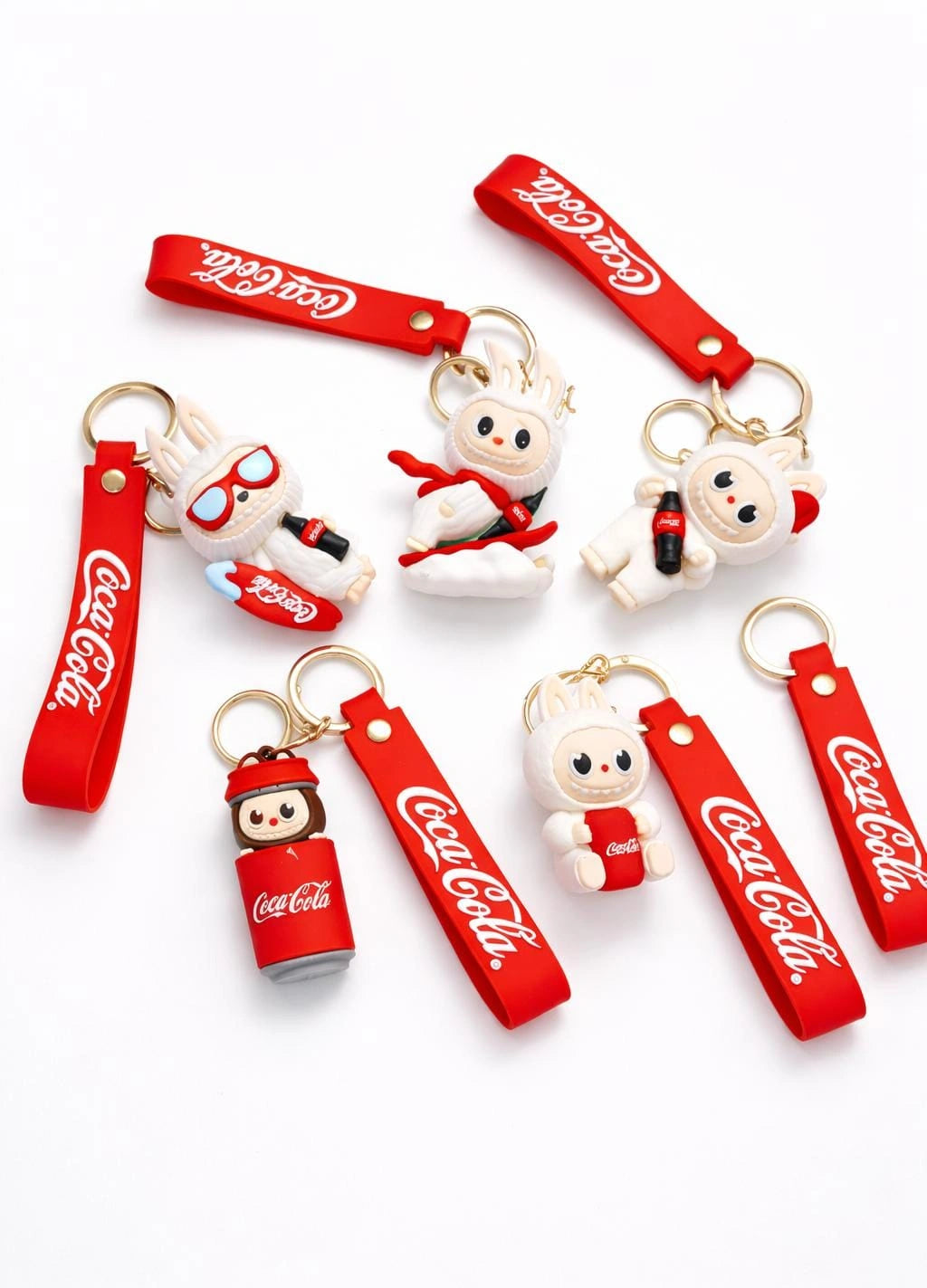 Coca-Cola themed keychains with cartoon characters on a white background