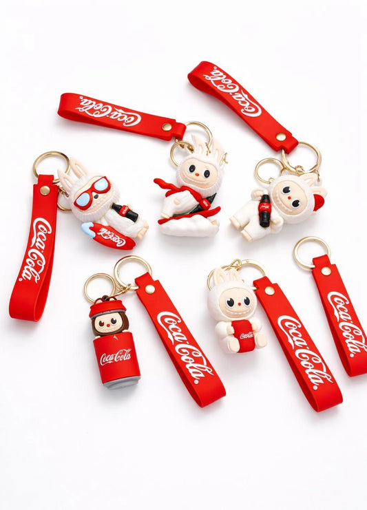 Coca-Cola themed keychains with cartoon characters on a white background