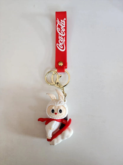 Keychain with a rabbit figure and Coca-Cola strap on a light gray background