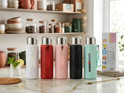 Five insulated water bottles in white, red, pink, black, and mint green are lined up on a marble countertop in a bright kitchen setting, with a product box standing to the right.