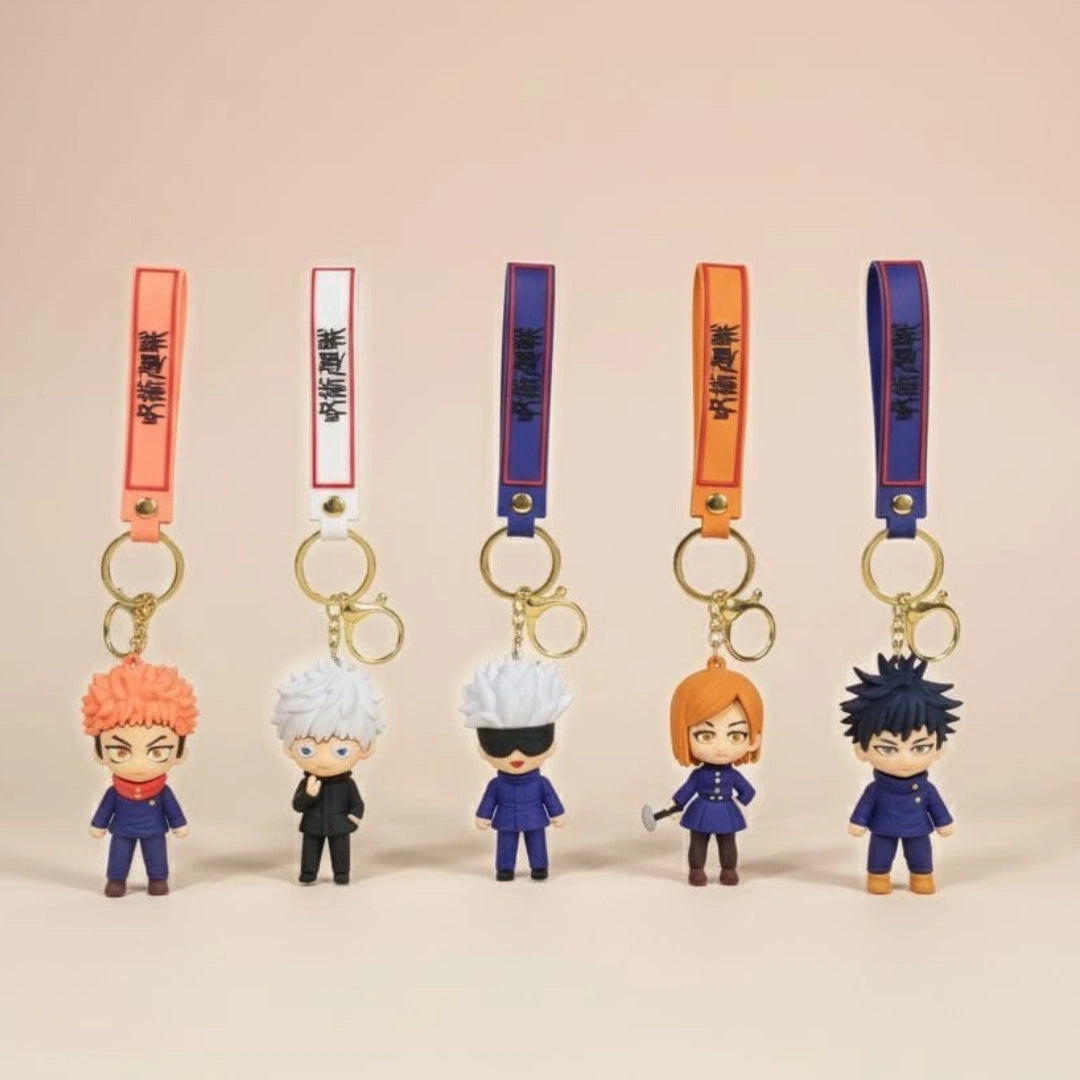 Five cartoon character keychains with colorful straps on a beige background