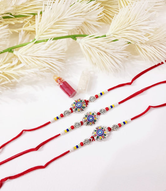 Two red rakhi ribbons with decorative beads on a white background