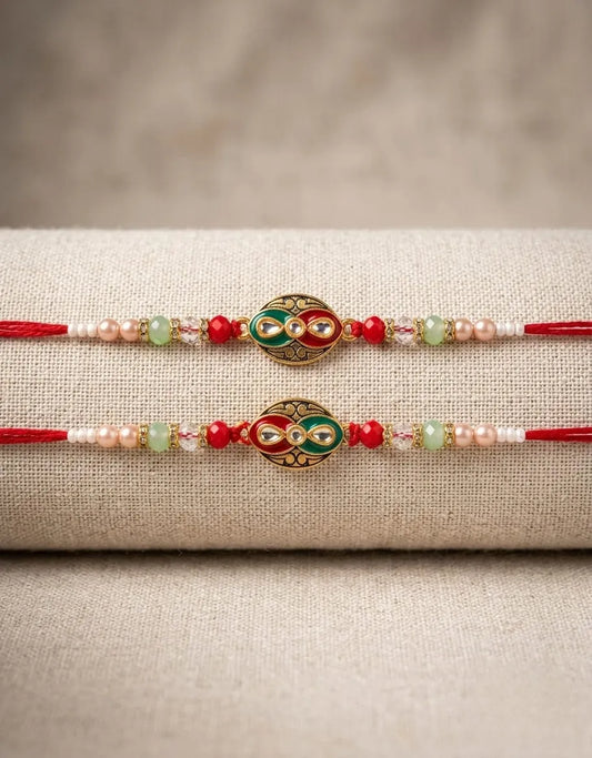 Two decorative bracelets with red, green, and gold elements on a textured beige surface.