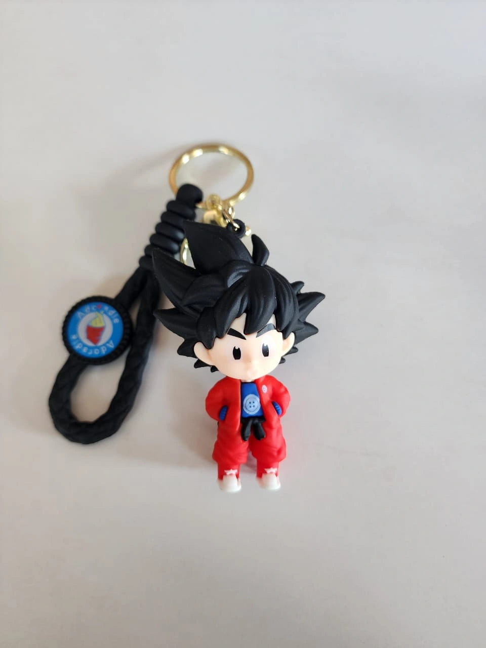 Keychain with character figure and black cord on a light gray background