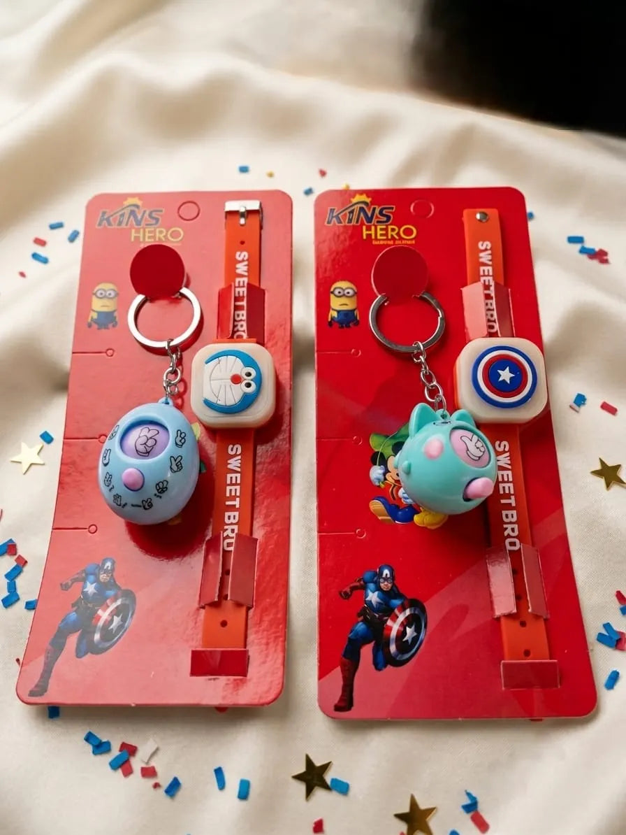 Two packaged kids' superhero-themed keychains on red backing cards, displayed on a white fabric background with confetti and star decorations. One keychain has a blue round character charm and a white square charm, and the other has a teal cat-shaped charm and a white square charm with a Captain America shield.