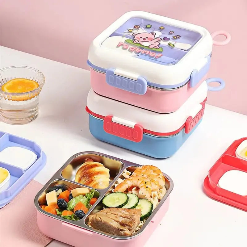 A stack of three reusable lunch boxes with a cartoon pig design on the lid, shown alongside an open compartment lunch box filled with food on a pink tabletop.