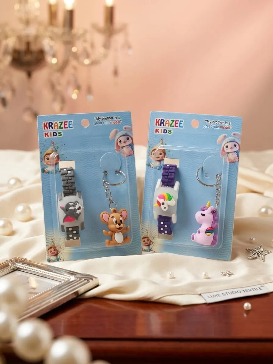 Two packaged KRAZEE KIDS wrist watch keychains displayed on a draped white fabric surface. One keychain has a gray bear character with a gray strap, and the other has a multicolor unicorn character with a purple strap.