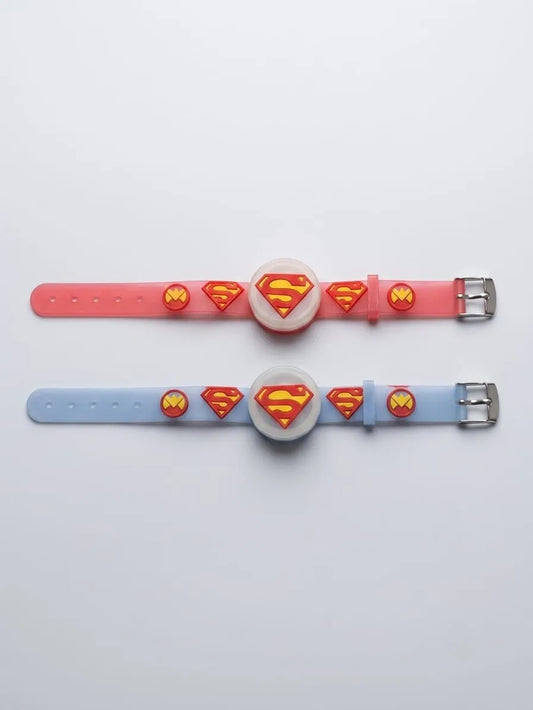 Two silicone watch bands with circular watch faces, featuring Superman logo designs in red and yellow. One band is pink and the other is light blue, laid flat on a white background.