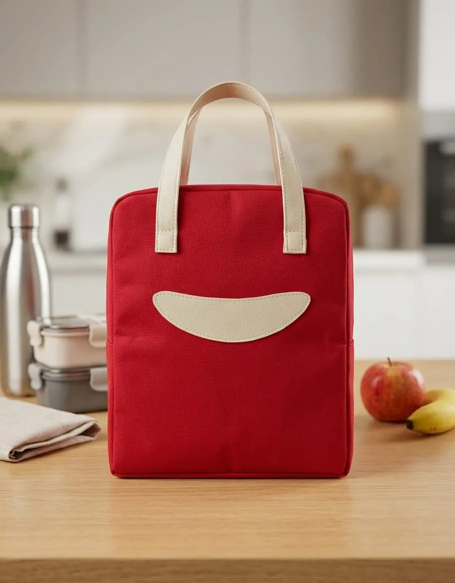 Red tote bag with a beige handle and patch on a kitchen counter.