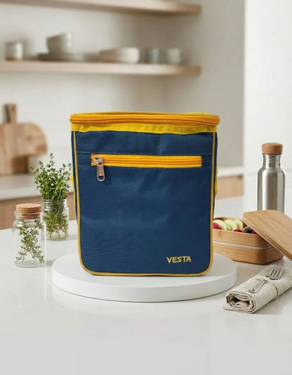 Blue and yellow insulated lunch bag with 'Vesta' branding on a kitchen counter.