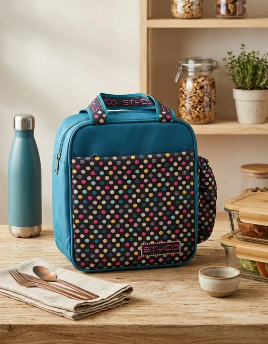 Blue insulated lunch bag with colorful pattern on a wooden table with a water bottle and utensils.