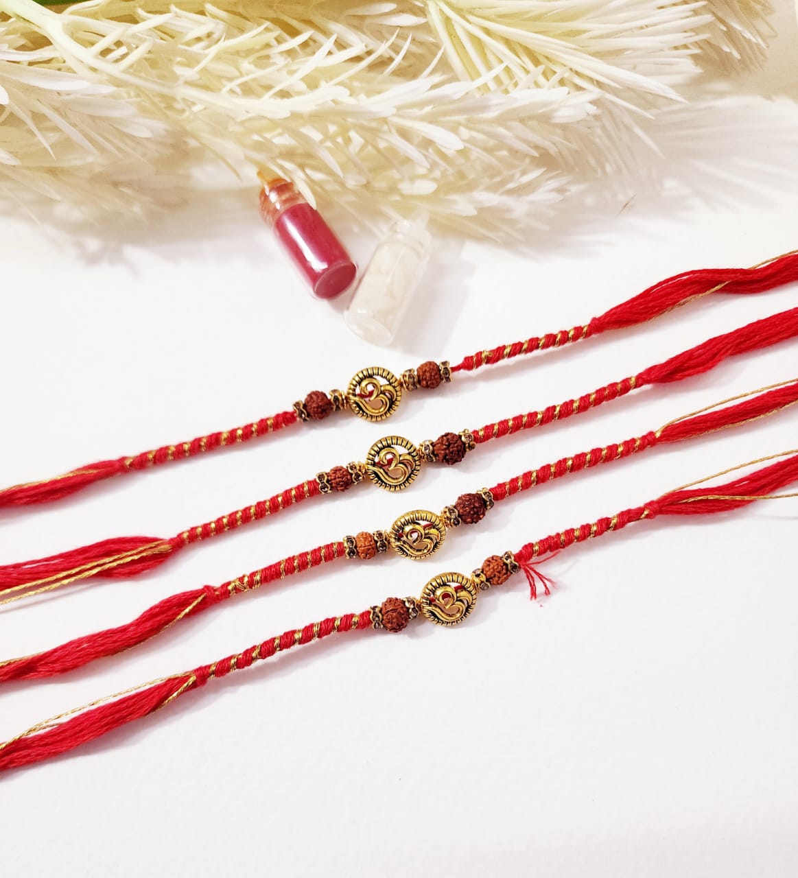 Three red and gold bracelets on a white background