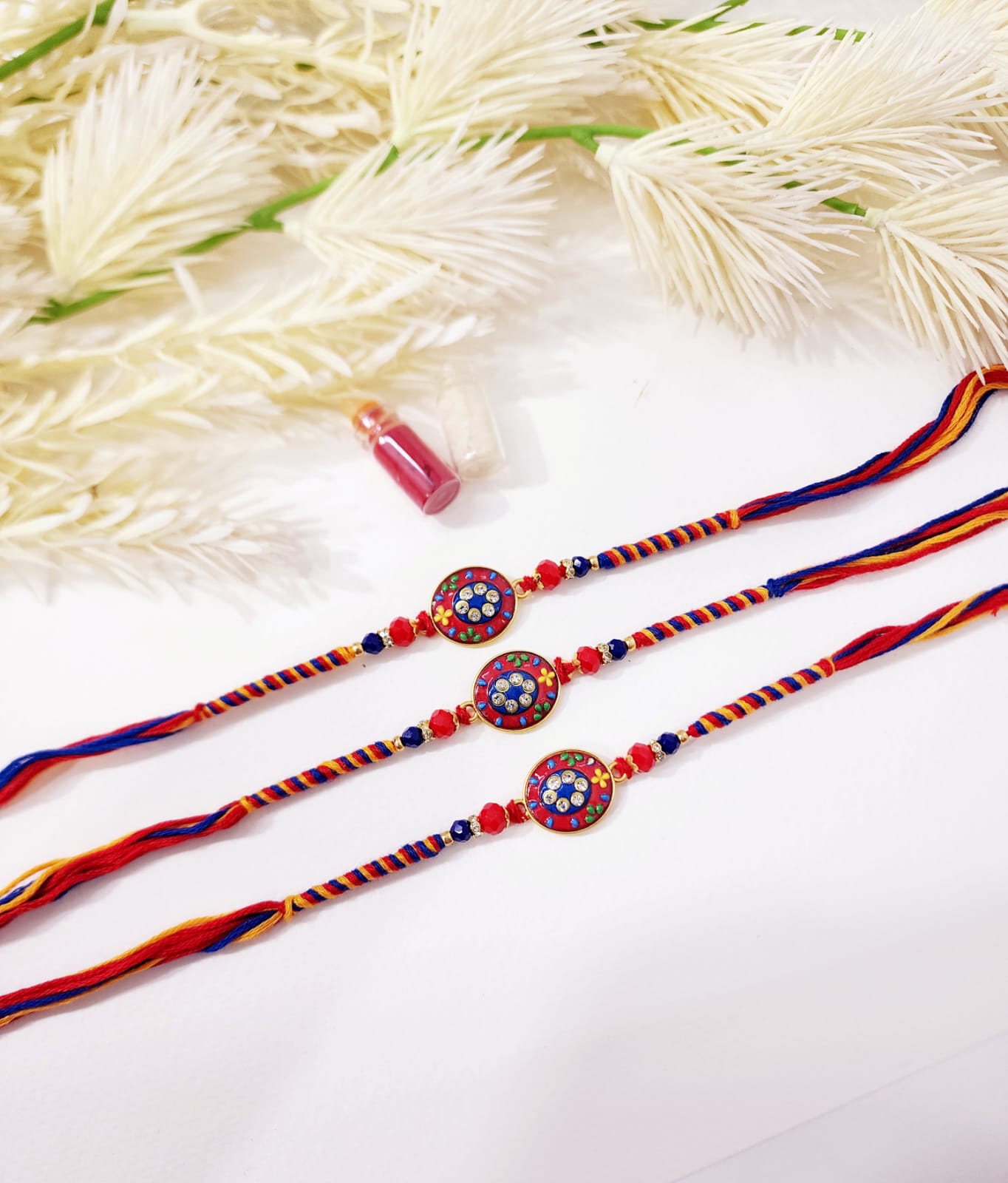 Three colorful bracelets with decorative elements on a white background