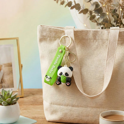 Panda keychain with a green tag on a beige tote bag with a blurred background