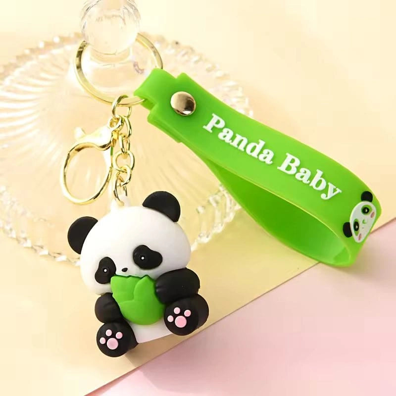 Panda keychain with a green band labeled 'Panda Baby' on a light pink background