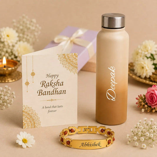 A personalized Raksha Bandhan gift set featuring a gold-plated bracelet engraved with 'Abhishek', a matte beige water bottle with a silver cap engraved with 'Deepak', and a cream-colored greeting card with gold mandala designs and 'Happy Raksha Bandhan' text. The set is styled with a lavender gift box, flowers, and a lit candle on a beige background.