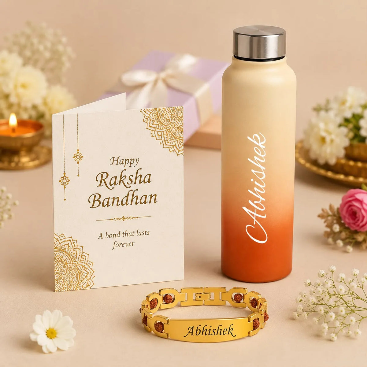 Personalized Raksha Bandhan gift set featuring a cream-to-orange gradient water bottle, a gold-plated bracelet with red stones and 'Abhishek' engraving, and a matching 'Happy Raksha Bandhan' greeting card, styled with flowers and a gift box on a beige surface.
