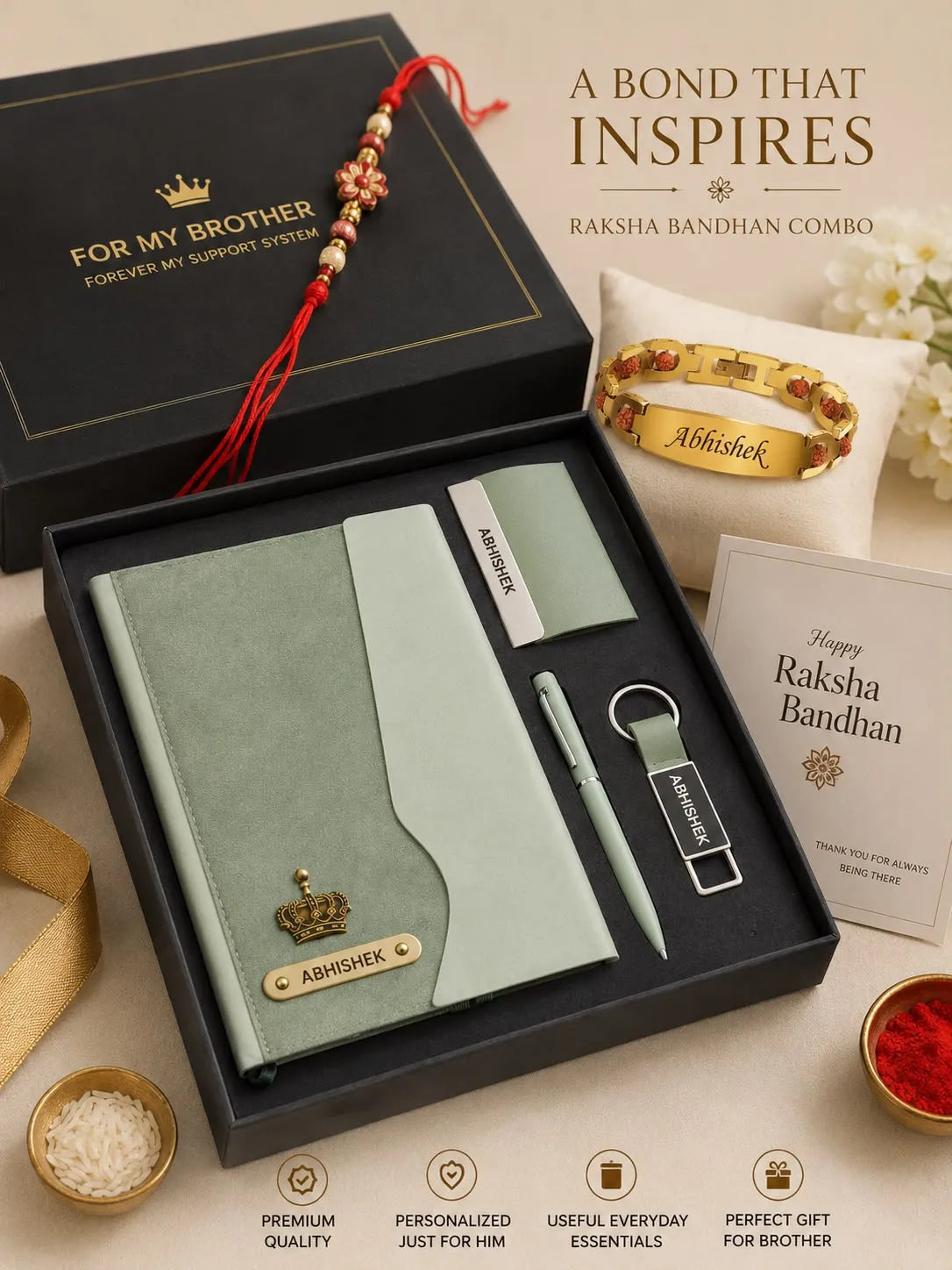 A Raksha Bandhan gift set displayed in an open black box on a beige surface. The set includes a pale green notebook with a gold nameplate, a matching pen, a branded card, a gold bracelet with red stones, and a red thread amulet.