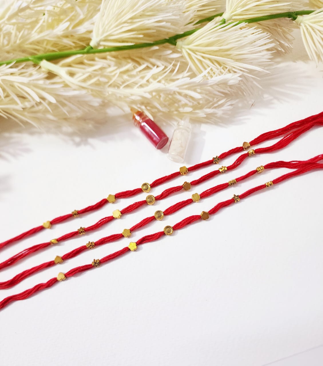 Red strings with gold beads on a white background