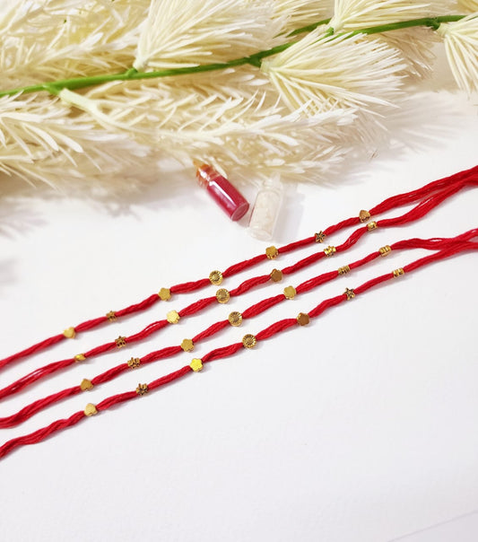 Red strings with gold beads on a white background
