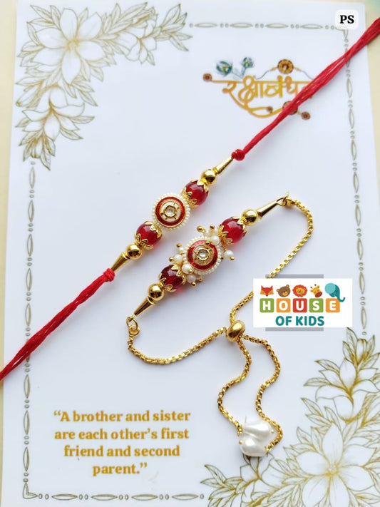 Two gold and red rakhi on a decorative card with floral patterns and text.