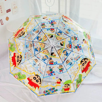 A clear plastic umbrella with a colorful cartoon print of Crèène characters, shown open on a white bed.