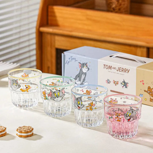 Set of glass tumblers with Tom and Jerry designs on a wooden surface.