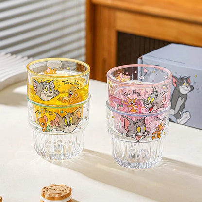Two stackable glasses with cartoon character designs on a light surface.