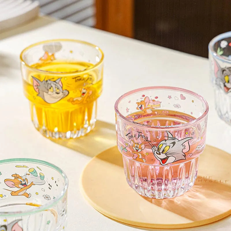 Set of glass tumblers with cartoon character designs on a light surface.