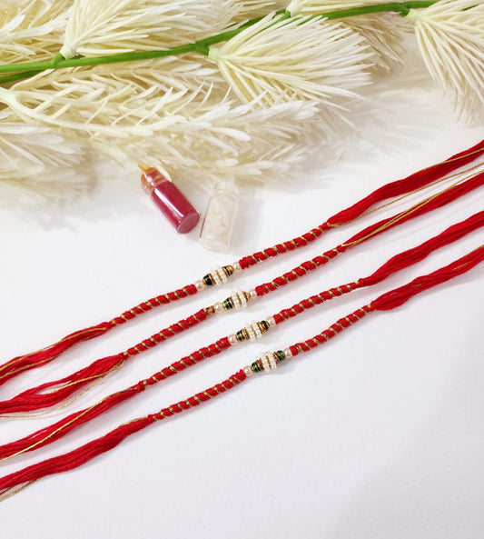 Red strings with gold beads on a white background