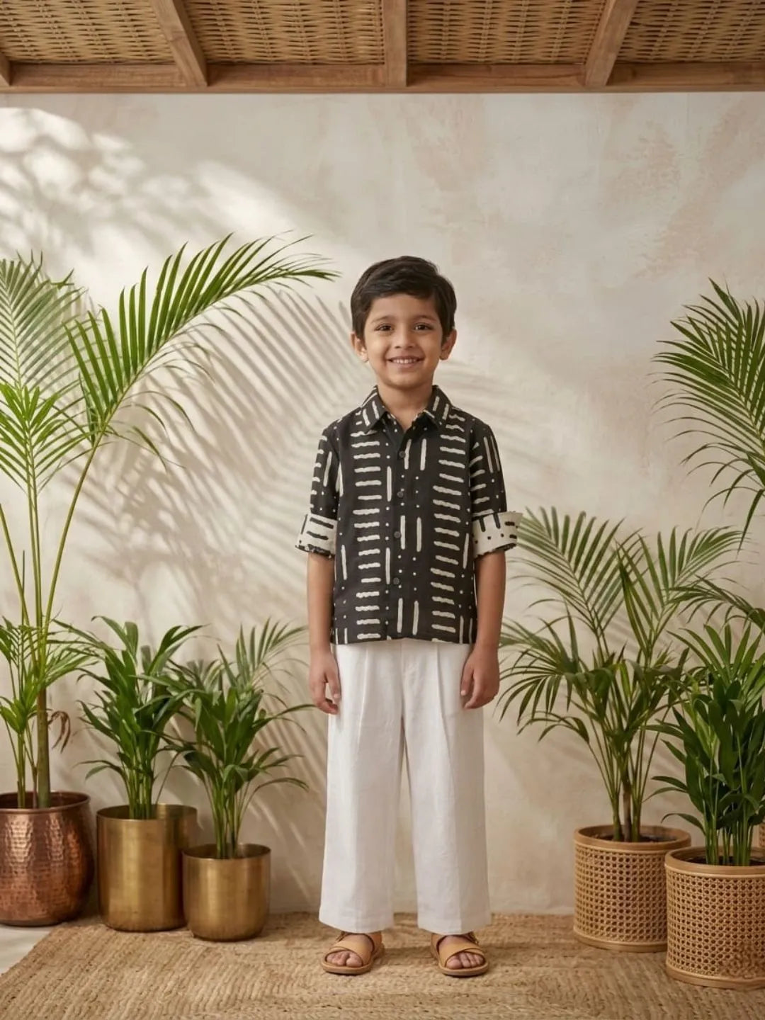 Kids black abstract print shirt and white pants outfit front angle