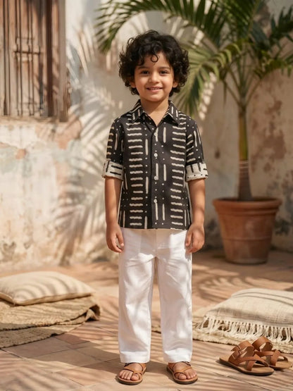 Boys stylish black printed cotton shirt with white trousers front view