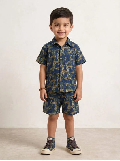 Child wearing a blue patterned shirt and shorts set on a white background
