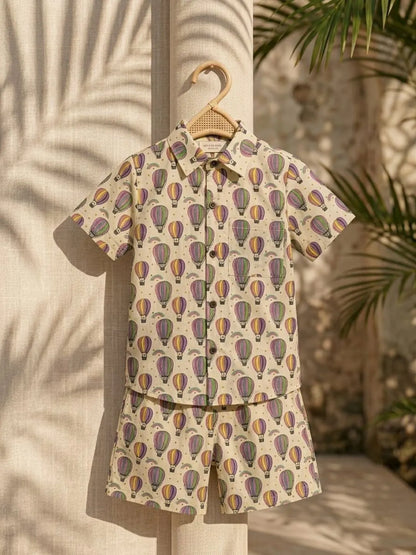 Children's outfit with hot air balloon pattern on a hanger against a natural background