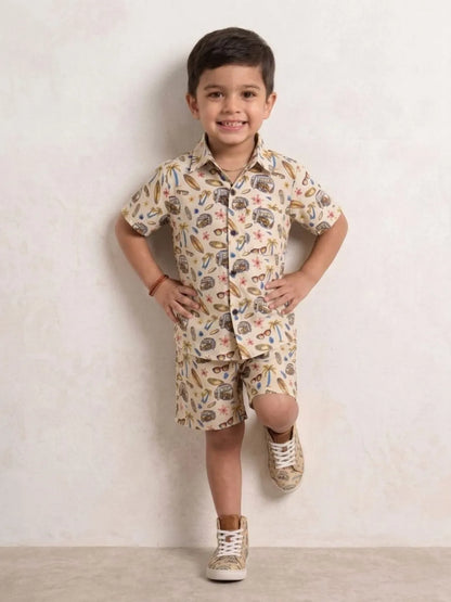 Child wearing a patterned shirt and shorts set with white sneakers on a plain background