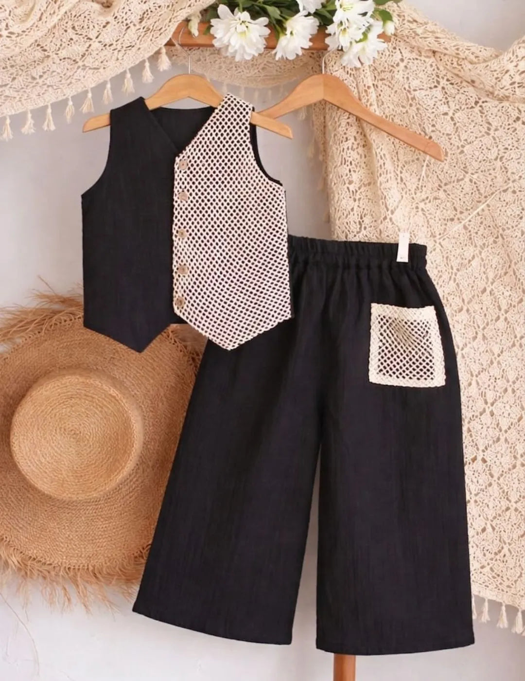 Close-up of black co-ord set highlighting contrast printed panel and pocket detail