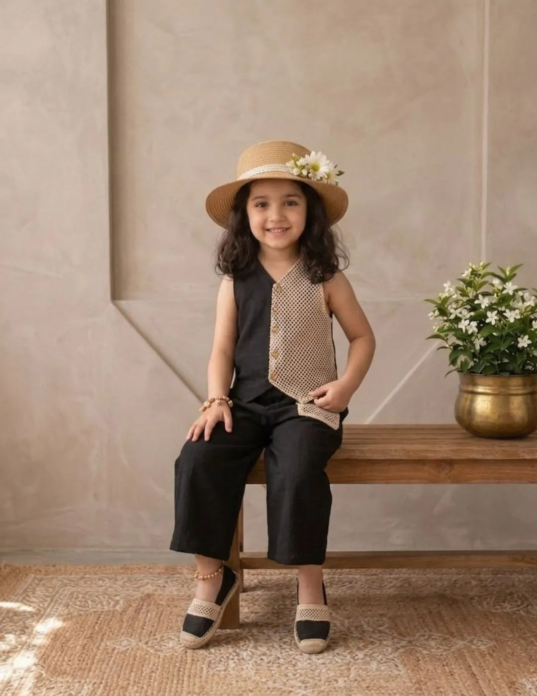 Full outfit look of girls black cotton co-ord set styled with hat and flats