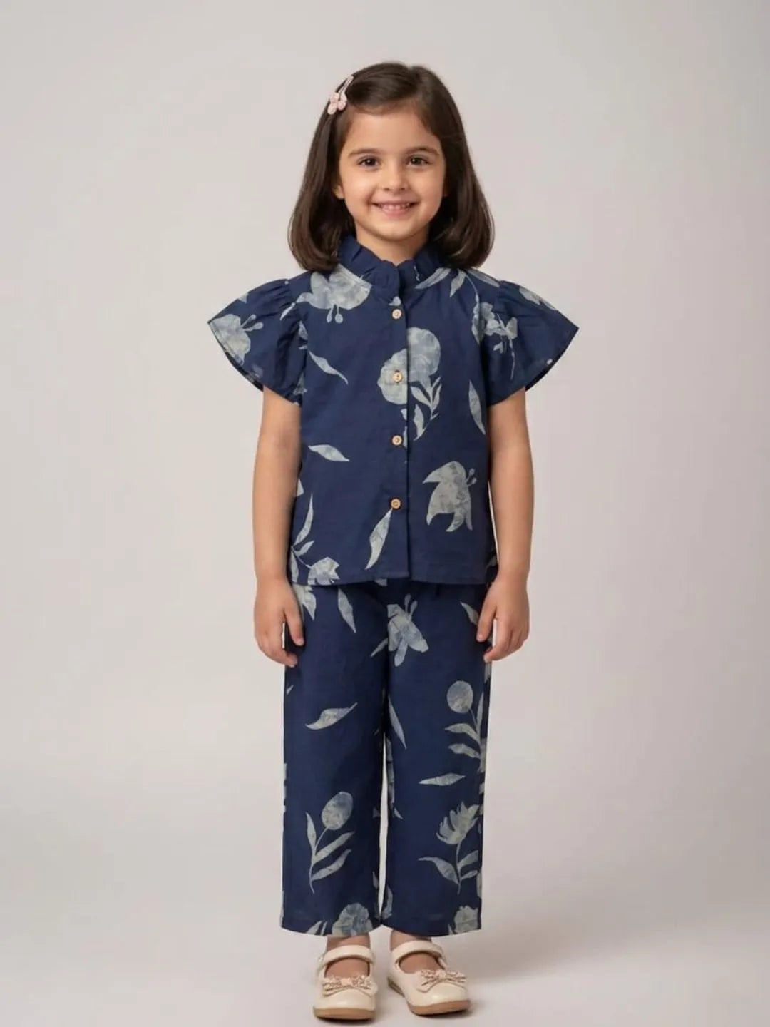 Girl wearing blue floral cotton co-ord set with flutter sleeves front view