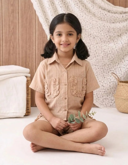 Girls cotton co-ord set sitting pose with ruffle detail shirt and shorts