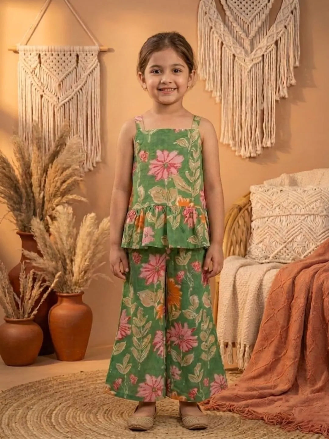 Girl wearing green floral co-ord set front angle view with sleeveless peplum top and wide leg pants
