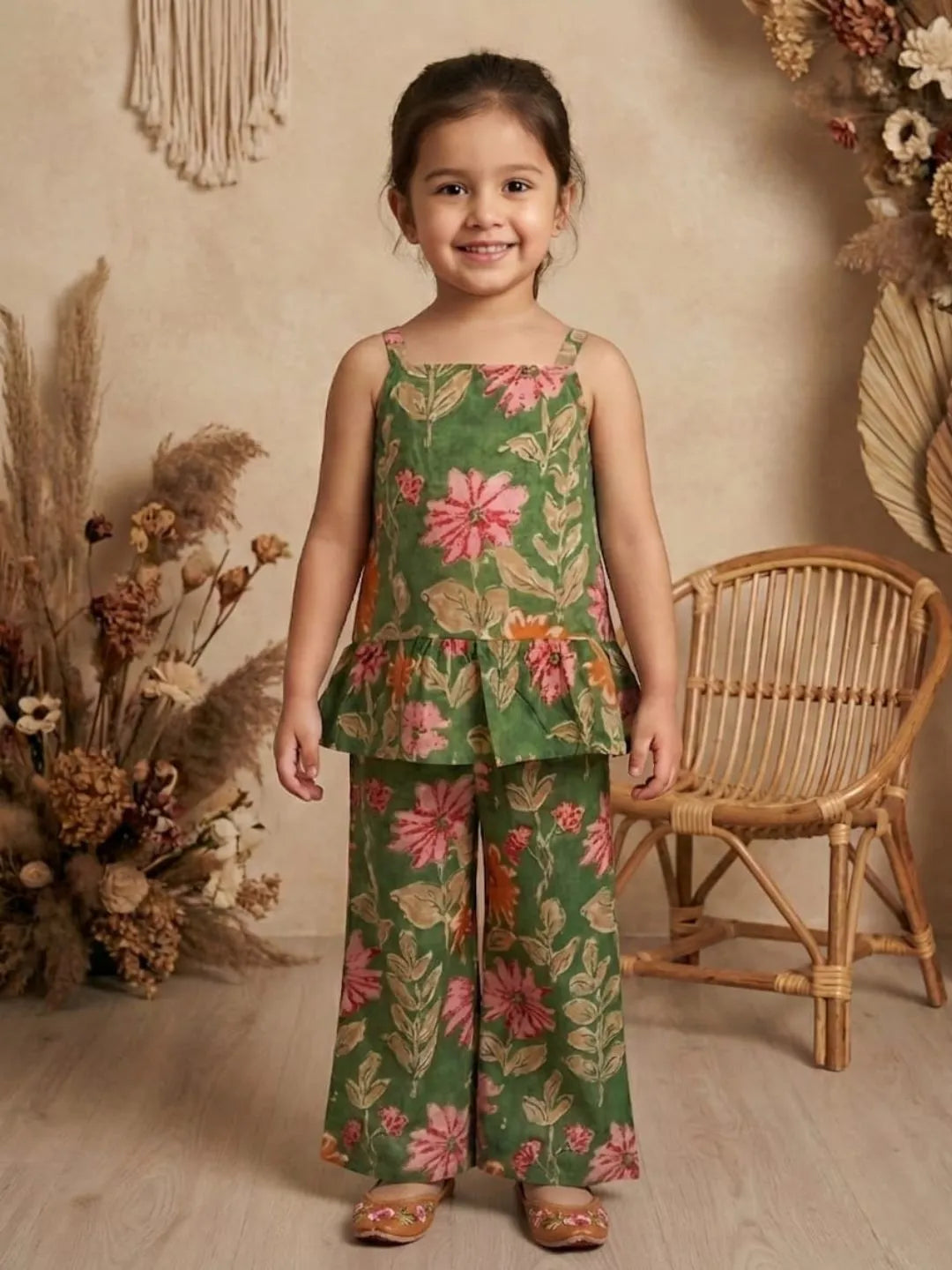 Girl wearing green floral co-ord set with sleeveless peplum top and wide leg pants front view