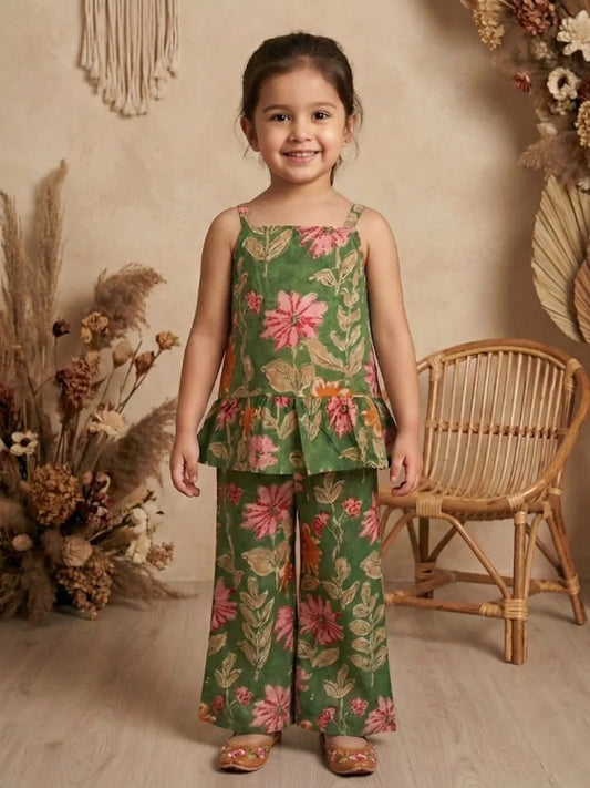 Girl wearing green floral co-ord set with sleeveless peplum top and wide leg pants front view