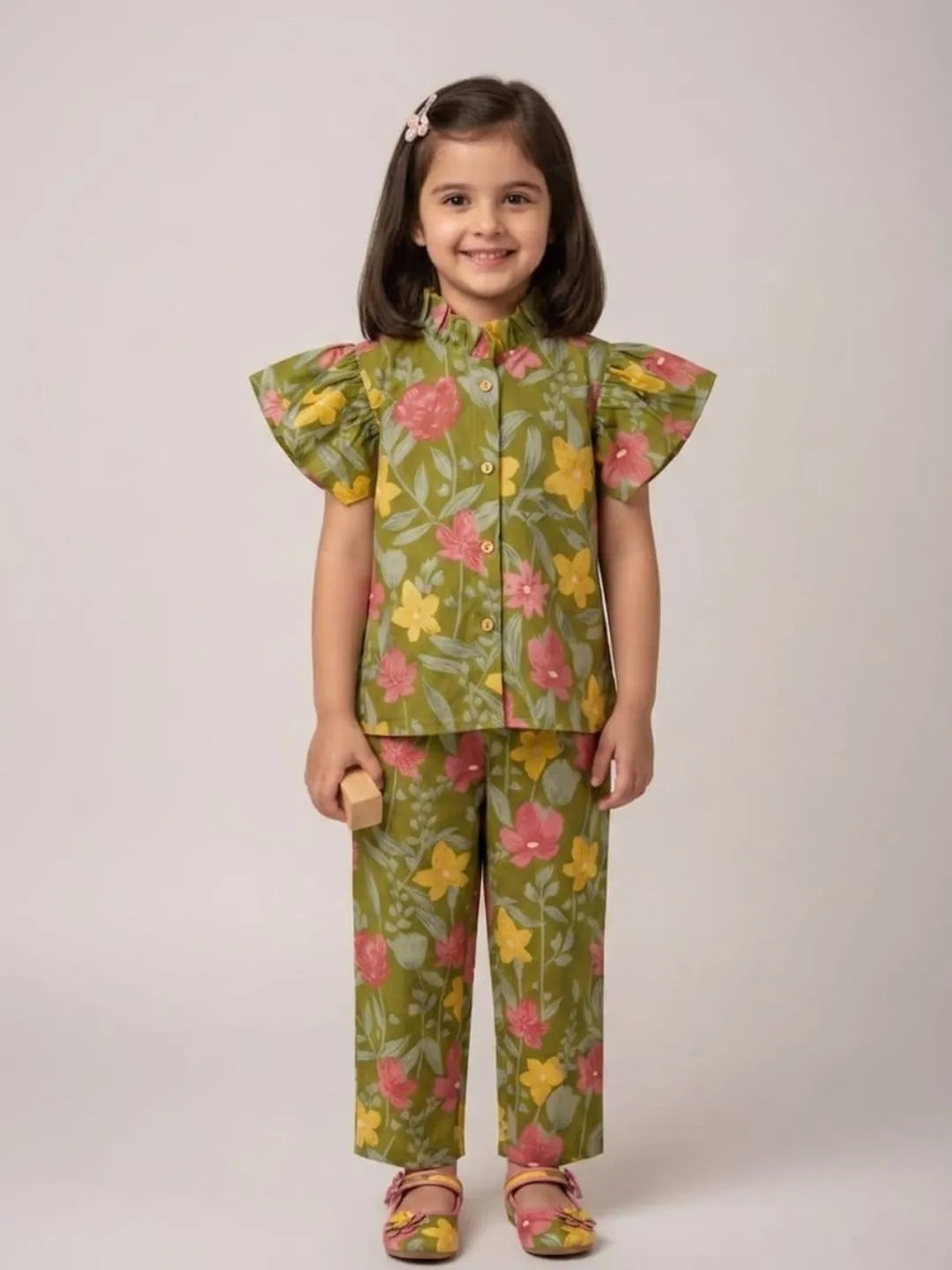 Girl wearing green floral cotton co-ord set with flutter sleeves front view